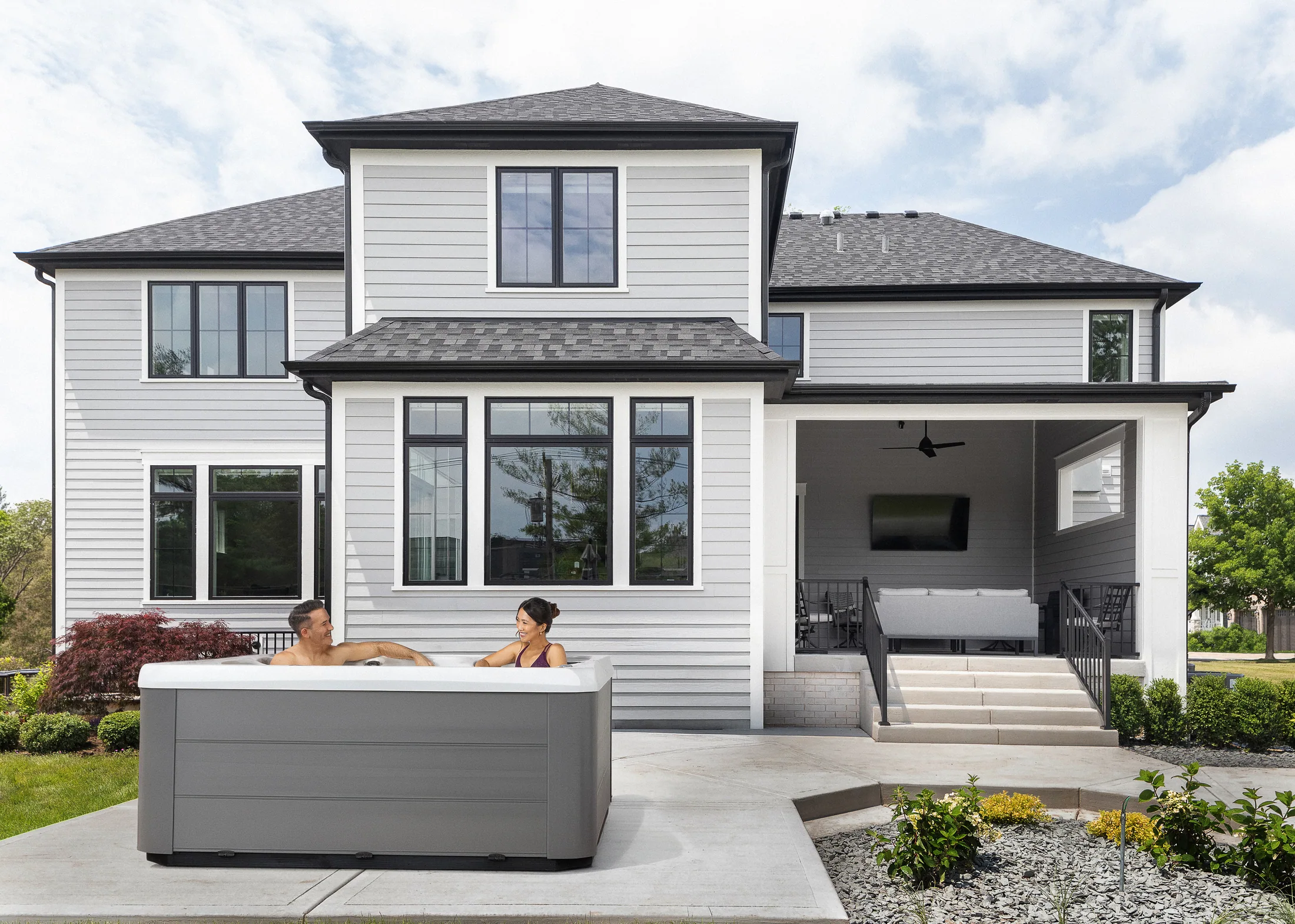 Hot tub on a patio in front of a home